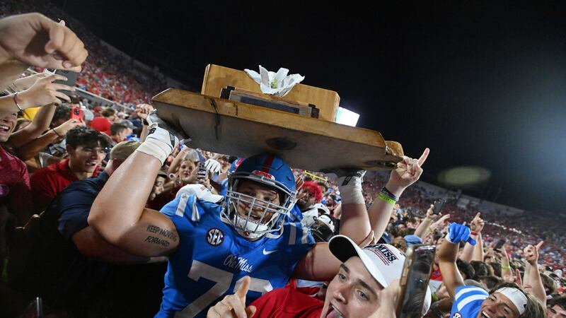 Mississippi offensive lineman Eli Acker, center, celebrates with fans after an NCAA college...