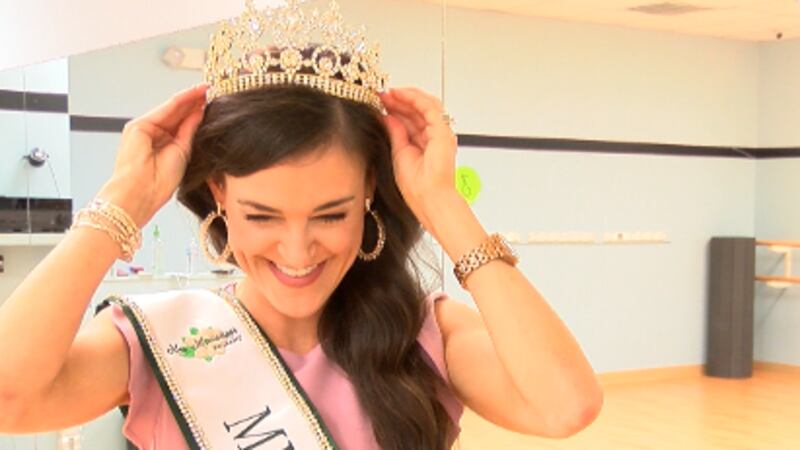 Sarah Williams shows off her crown and sash in her dance studio before a class.