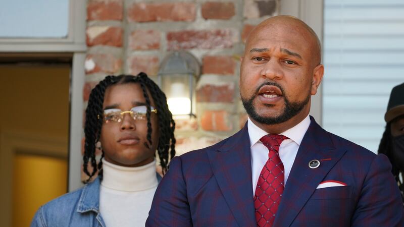 FedEx driver D'Monterrio Gibson, left, stands next to his attorney, Carlos Moore, during a...