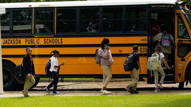 FILE - Spann Elementary School students board a school bus following a full day of in-school...